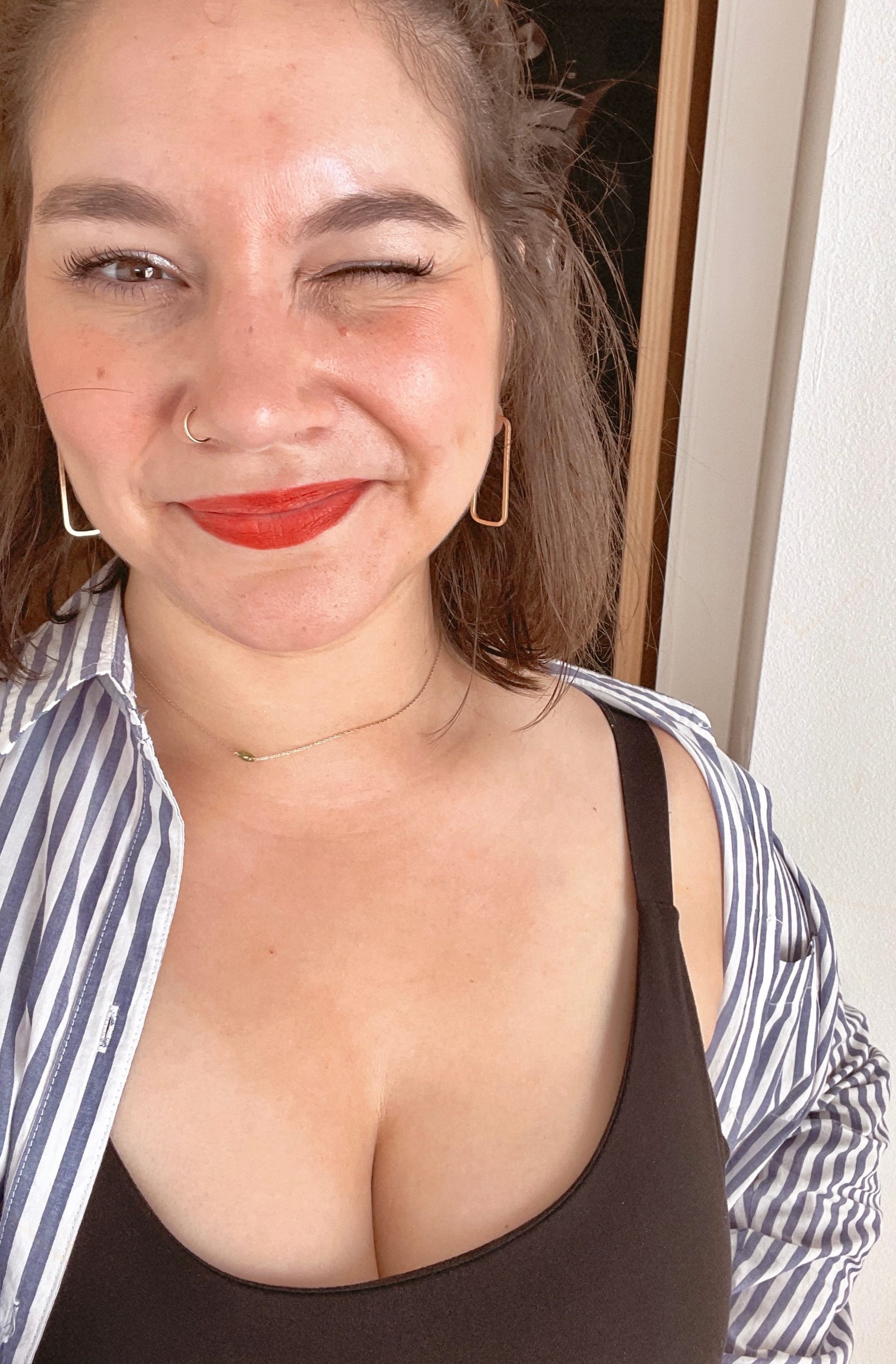 Picture of woman with red lipstick smiling with a striped shirt