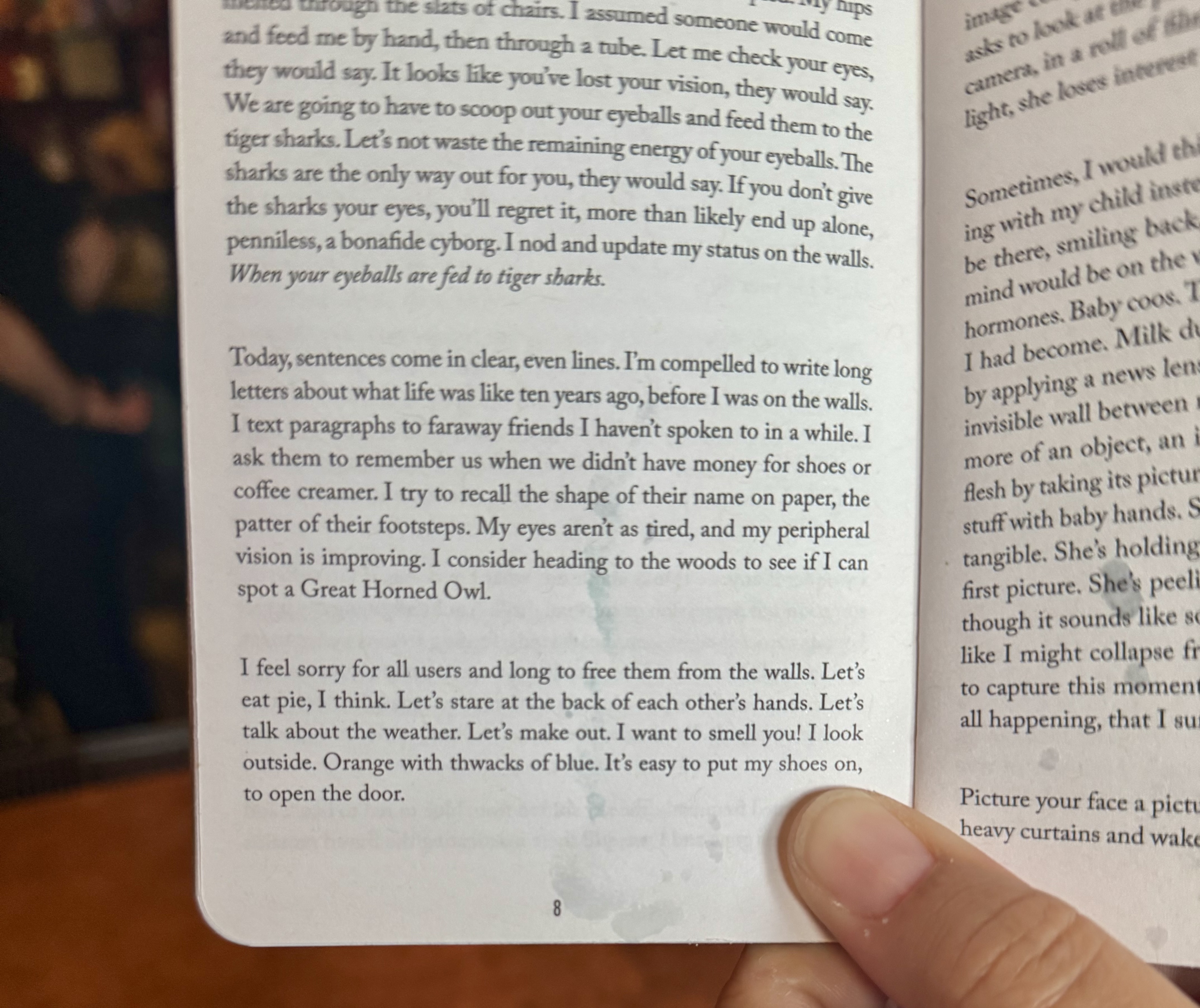 Photo of person's thumb holding a tiny book with words printed on the page.