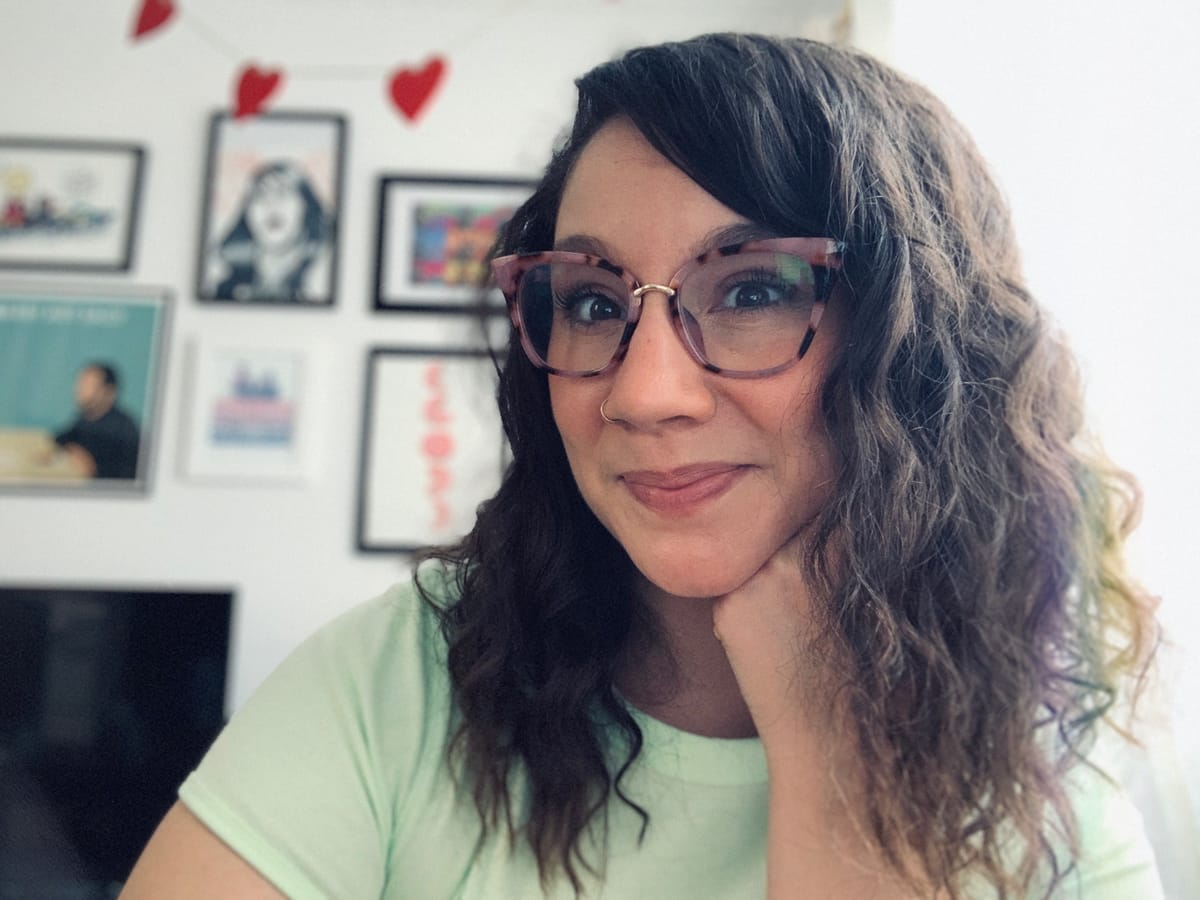 woman smiling in front of a gallery wall at home