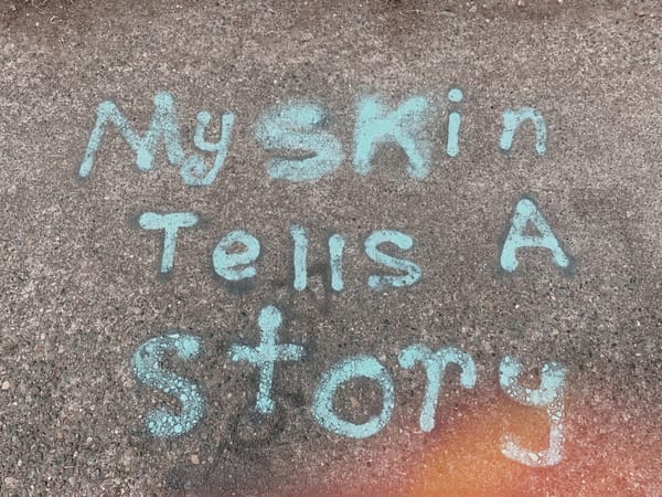 graffiti that reads "my skin tells a story"